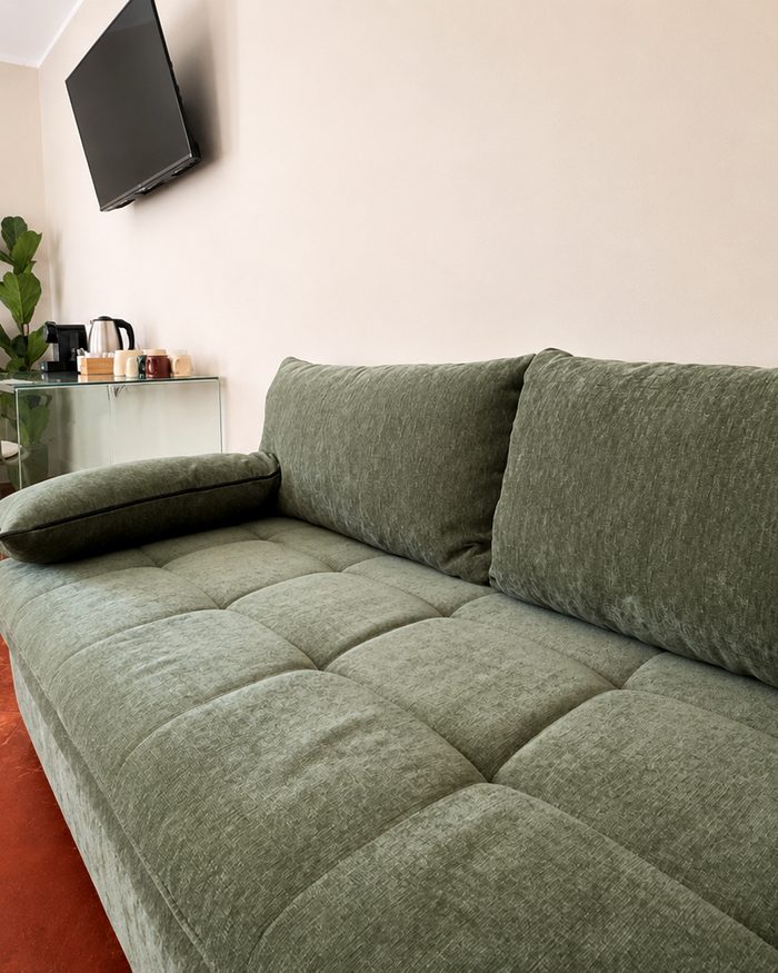 Borgo Suites, divano verde e pavimento in cotto